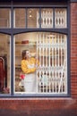 Female Small Business Owner Pushing Back Security Grill And Opening Shop