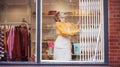 Female Small Business Owner Pushing Back Security Grill And Opening Shop Royalty Free Stock Photo