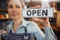 Female Small Business Owner Turning Around Open Sign On Shop Or Cafe Window Or Door Royalty Free Stock Photo