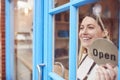 Female Small Business Owner Turning Around Open Sign On Shop Or Store Door Royalty Free Stock Photo