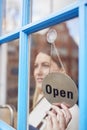 Female Small Business Owner Turning Around Open Sign On Shop Or Store Door Royalty Free Stock Photo