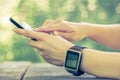 Female with smart watch on her hand using smartphone Royalty Free Stock Photo