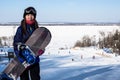 A female snowboarder with a snowboard in the mountains. Royalty Free Stock Photo