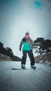 Female snowboarder on the top of a hill, as she prepares to take a ride down the snow-covered slopes Royalty Free Stock Photo