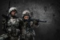 Female soldier aiming rifle near her black comrade Royalty Free Stock Photo