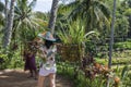 A female solo traveller enjoying a hot summer day wearing shorts and carrying paddy rice in bucket in Bali