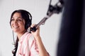 Female Sound Recordist Holding Microphone On Video Film Production In White Studio Royalty Free Stock Photo