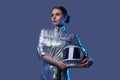 Female space explorer in spacesuit holding helmet