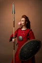 Female spartan warrior with shield and spear and chewing gum