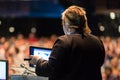 Female public speaker giving talk at Business Event.