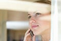 Female speaking over the cellphone , view through a glass. Young woman having a conversation over the cellphone , view