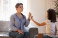 Female speech therapist doing exercise, speaking with little girl patient