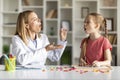 Female Speech Therapist Having Lesson With Cute Little Girl