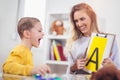 Speech therapist teaches the boys to say the letter A Royalty Free Stock Photo