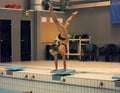 A female swimmer, that ready to jump into indoor sport swimming pool. standing on arms with legs up Royalty Free Stock Photo