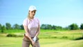 Female in sportswear with golf club ready to hit ball at course, elite hobby Royalty Free Stock Photo