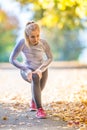 Female sporty young woman doing stretching or warming the body and preparing to jogging