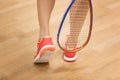 Female squash player hiting a ball in a squash court