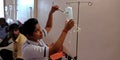 female staff injecting needle into the glucose bottle during treatment