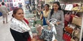 female staff presenting hand bag to the lady customer at showroom