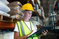 Female staff using digital tablet in warehouse