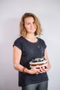 Female stand with finished utensils, smiling ceramist workplace with baked cups