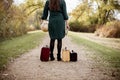 Female standing in between her old suitcases while holding a desk globe and the bible Royalty Free Stock Photo