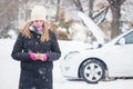Female standing next to broken car and using mobile assistance smart phone app. Royalty Free Stock Photo