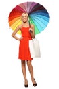 Female standing under umbrella with shopping bag