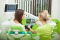 Female stomatologist in protective gloves examining patient`s teeth. Dentist caries treatment at dental clinic office Royalty Free Stock Photo