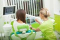 Female stomatologist in protective gloves examining patient`s teeth. Dentist caries treatment at dental clinic office Royalty Free Stock Photo