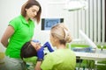 Female stomatologist in protective gloves examining patient`s teeth. Dentist caries treatment at dental clinic office Royalty Free Stock Photo