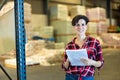 Female storekeeper checks availability of goods with documents in the building materials warehouse