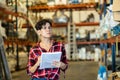 Female storekeeper checks presence of goods in the building materials warehouse