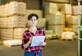 Female storekeeper checks presence of goods in the building materials warehouse