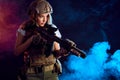 Woman soldier sniper in disguise with a sniper rifle and aims in smoky darkness Royalty Free Stock Photo