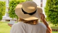 female in a straw hat holds a cup of hot drink and drinks coffee, sitting in the morning on a summer terrace on a sunny Royalty Free Stock Photo