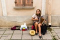 A female street musician plays the accordion on a side walk in the old town of Tallin