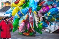 Female street vendor sells helium balloons at Christmas funfair Hyde Park Winter Wonderland in London