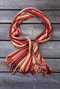 Female striped scarf on wooden background.