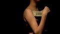 Female stroking her body with hundred dollar banknote, prostitute in bawdy house Royalty Free Stock Photo