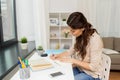 Female student with book learning at home