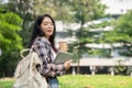 A female student carrying her backpack, digital tablet, and a coffee cup standing in a campus park Royalty Free Stock Photo