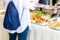 Female student choosing finger food from buffet table