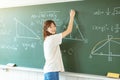 Female student in the classroom writing on chalkboard  mathematical equations Royalty Free Stock Photo