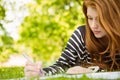 Female student doing homework in park