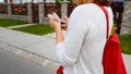 Female student earphones looking in smartphone app, walking street, life danger
