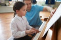 Female Student Enjoying Piano Lesson With Teacher