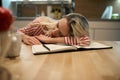 A female student fell asleep while studying at the kitchen. Student, tired, studying Royalty Free Stock Photo