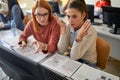 A female student giving help to a colleague at the informatics lecture. Smart young people study at the college. Education, Royalty Free Stock Photo